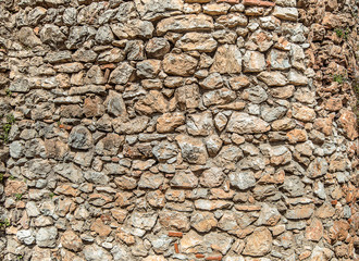 Texture of old stone wall. Surface from grey and orange stones. Ancient wall in Macedonia
