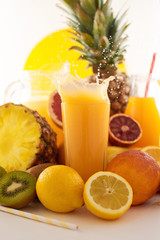 Fresh juice dynamic splash. A glass of fruit drink and fruits on a white background. Delicious, tasty, sweet summer set. 