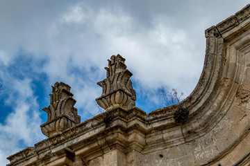 Obraz premium Rooftop decorations, architectural detail from the historic center of Matera, Italy, Basilcata region, low point of view from below, scenery summer day with puffy white clouds