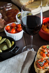 Wooden dining table set with tapas dishes and red wine