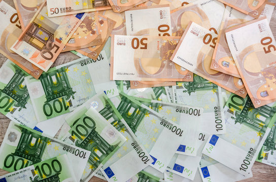 Euro banknotes as background on wooden desk 