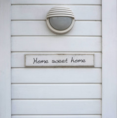 weisse Holzwand mit der Aufschrift "Home sweet home"