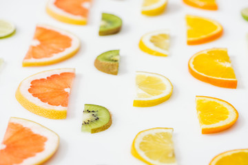 Juicy fresh sliced citrus fruits on white surface