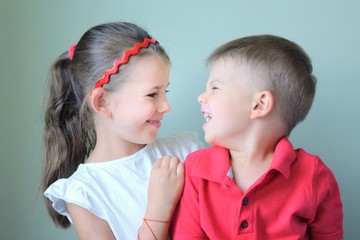 Two little Caucasian kids eat strawberries. Brother and sister eating healthy organic strawberry, fresh red berries. Happy children girl and boy feed each other strawberries. Fresh berries as snack