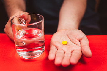 medicine, health care and people concept - close up of a man taking in pill