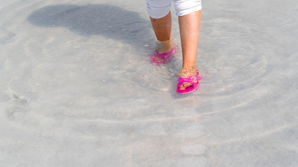 Woman wearing red or pink slipper walking on the famous tourist destination Salt Lake (Turkish: Tuz Golu) is the second largest lake in Turkey.