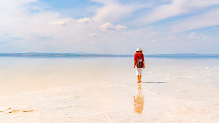 Silhouette of woman wearing red shirt and white hat walking on the famous tourist destination Salt...