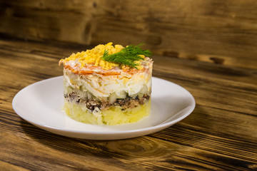 Traditional russian salad Mimosa on wooden table
