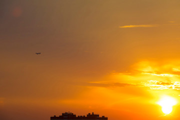 Fototapeta na wymiar Airplane Flies on Bright Evening Sunset