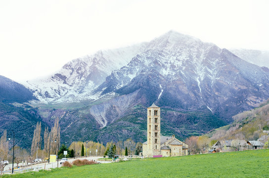 Picturesque town in a Vall de Boí,  Catalan Pyrenees, Spain. Romanesque church and snow mountains on the background