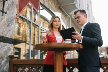 Handsome and Confident Businessman Using Laptop Computer and Technology Gadget Smartphone outdoor Discussing With Beautiful Business Partner .New Modern Business People Lifestyle.