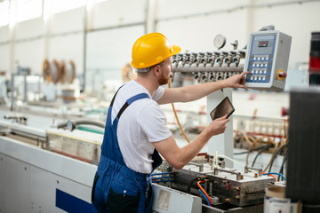 Factory worker. Man with helmet working with pvc.