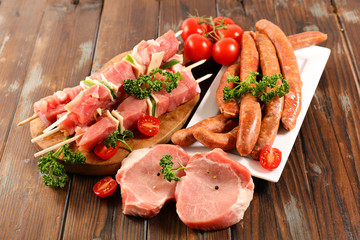 assorted raw meats on wood background