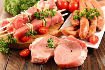 assorted raw meats on wood background