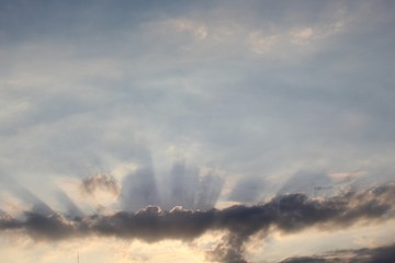 Naklejka na ściany i meble raios solares entre nuvens no céu azul