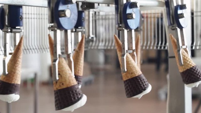 ice cream production, transportation waffle-cone with plombir ice cream on production line, dairy products.