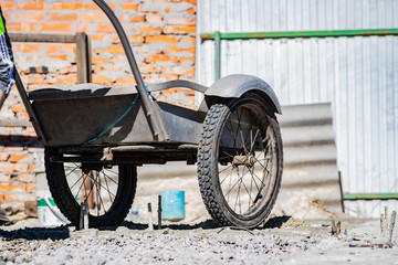 Simple small gravel, stones in grey in old aluminum car wheels. To transport the material and to...