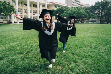 full length two young positive students graduation ceremony concept. beautiful elegant smiling...