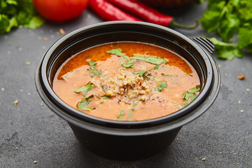 Traditional Georgian soup Kharcho with meat and rice on dark stone background