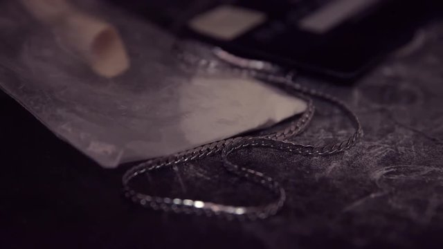 Slow panorama shot of a cocaine addict belongings. Isolated on black.