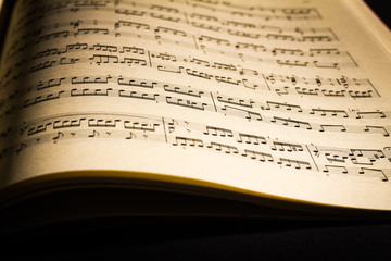 Naklejka premium Close-up of sheet music page, in black background