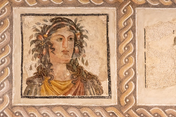 Ancient roman mosaic showing beautiful woman with flowers on her hair