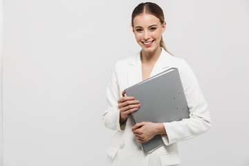 Fototapeta premium Beautiful amazing woman posing isolated over white wall background holding folder.