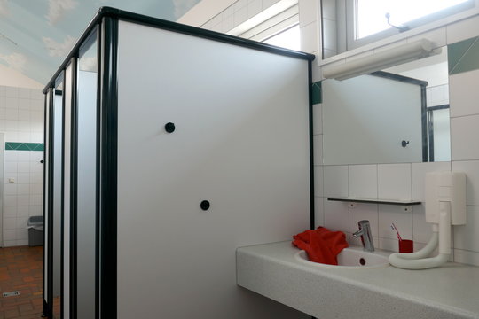 Modern sanitary room and sanitary facilities in a public building, Germany, Europe. Many sinks with mirrors, hairdryers, sinks and shower stalls.
