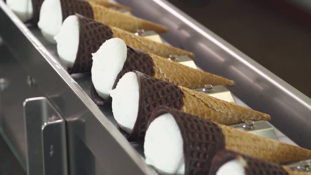 ice cream production, transportation waffle-cone with plombir ice cream on production line, dairy products.