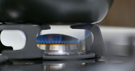 Stove top burner igniting into a blue for cooking