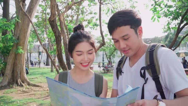 Traveler Asian couple direction on location map in Bangkok, Thailand, sweet Asia couple looking on map find landmark while spending holiday trip. Lifestyle couple travel in city concept.