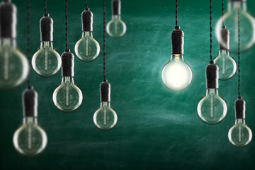 Idea and leadership concept Vintage incandescent Edison bulbs on color background