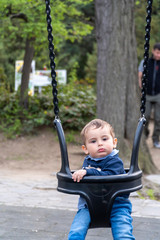 Small child sitting in a swing chair