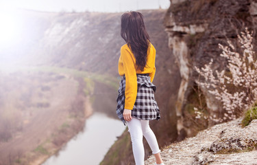 Naklejka premium Tourist traveler on background valley landscape. Young woman sitting alone 