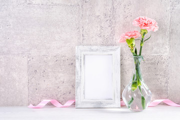 Close up, copy space, mock up, beautiful mothers day event concept handmade giftbox decoration photography, blooming fresh carnations with pink color ribbon isolated on gray wallpaper
