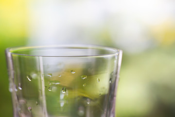 Water drops of transparent glass in bokeh green garden background, Close up & Macro shot, Selective focus, Healthy Drink concept