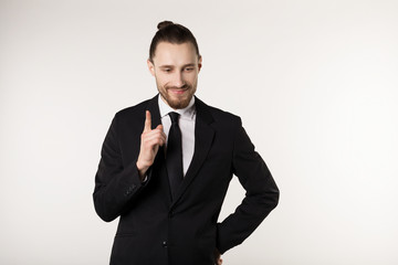 Happy beautiful bearded guy with good-looking hairstyle, wearing black suit and tie