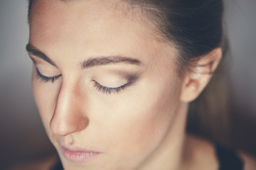 Fototapeta premium Young beautiful woman applying make-up by make-up artist. Process of making makeup.