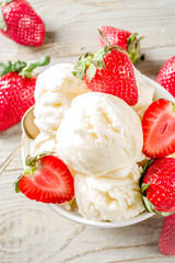 Homemade strawberry vanilla ice cream with fresh strawberries. Sweet berry summer dessert. Wooden background copy space