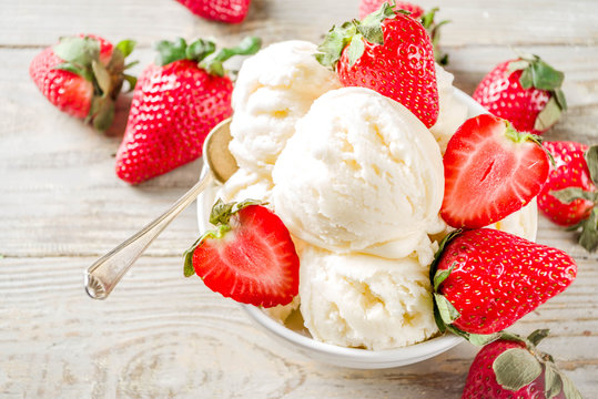 Homemade strawberry vanilla ice cream with fresh strawberries. Sweet berry summer dessert. Wooden background copy space