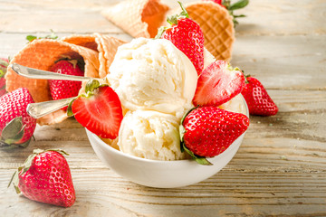 Homemade strawberry vanilla ice cream with fresh strawberries. Sweet berry summer dessert. Wooden background copy space
