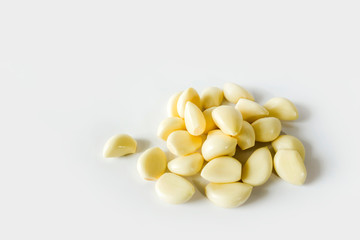 Peeled cloves of garlic on white background