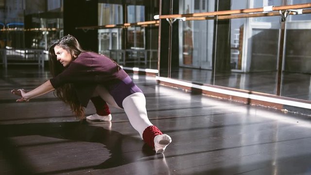 Young ballet dancer warming up body and stretching.Young ballet dancer warming up body and stretching.Young ballet dancer warming up body and stretching.