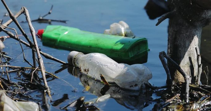 Environmental contamination. Water pollution old garbage on river surface. Pollution by plastic bottles in the water. Pattern of dirty floating objects in the sea.