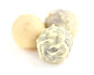 Three candies of white chocolate on white background. Selective focus