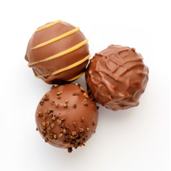 Three candies of milk chocolate on white background. Top view.