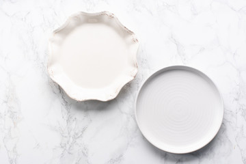 Porcelain plates of various forms on marble surface