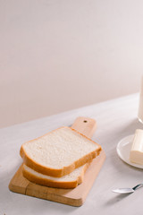Sliced bread bake and butter on wooden cutting board. Simple breakfast