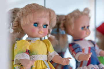 retro plastic doll in yellow and blue dress, mirror background