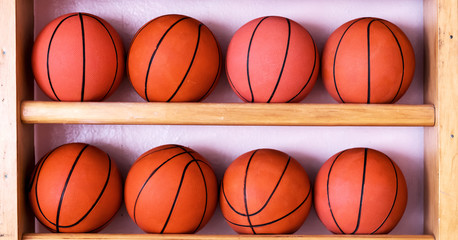 two rows of basketballs on the gym wooden stairs